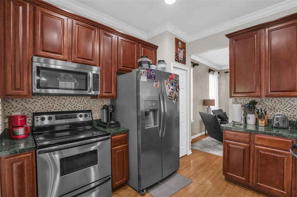 2165 Ridgewood Street Orlando, FL 32803 - Photo 12 of 37 a kitchen with granite countertop a refrigerator stove and microwave