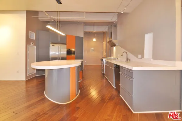 a kitchen with a refrigerator and wooden floor