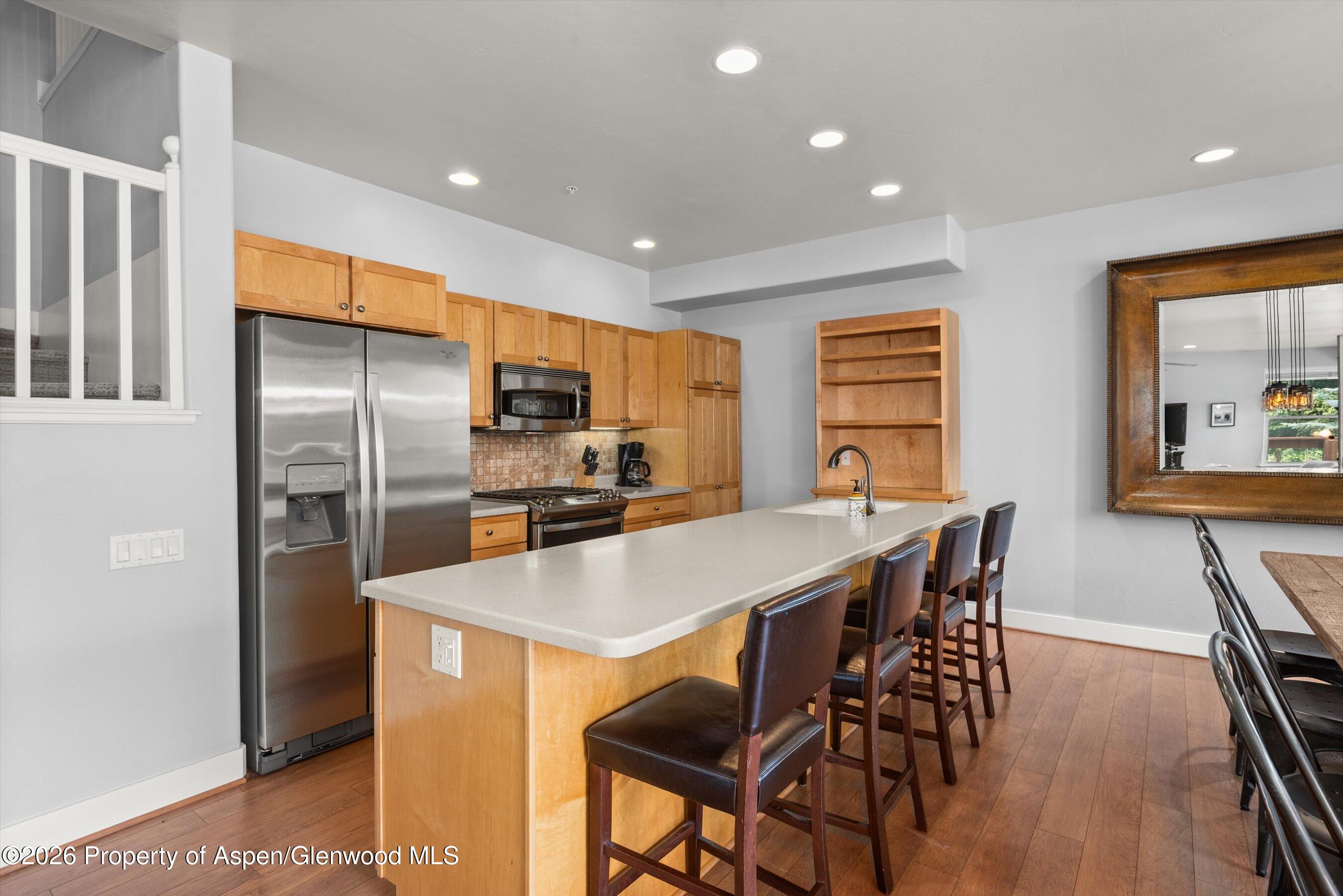 548 Evans Court Basalt, CO 81621 - Photo 12 of 36 a kitchen with stainless steel appliances a table chairs refrigerator and wooden floor