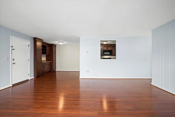 a view of a big room with wooden floor and windows