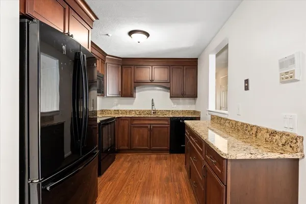 a kitchen with granite countertop stainless steel appliances and wooden cabinets