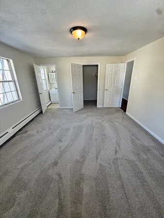 an empty room with windows and closet