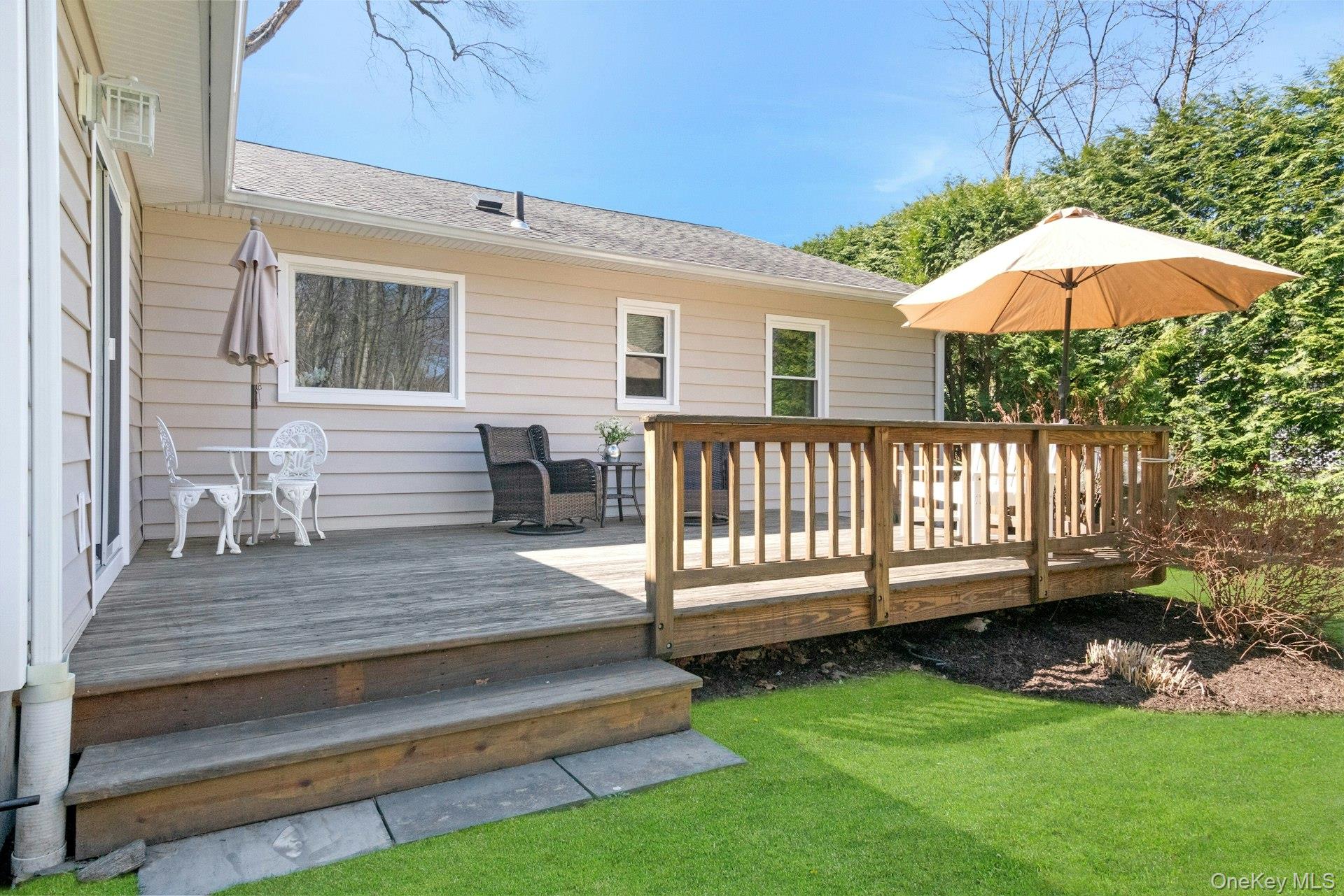 61 Schrade Road Briarcliff Manor, NY 10510 - Photo 27 of 39 Step down from the deck to the level backyard bordered by a natural rock garden.