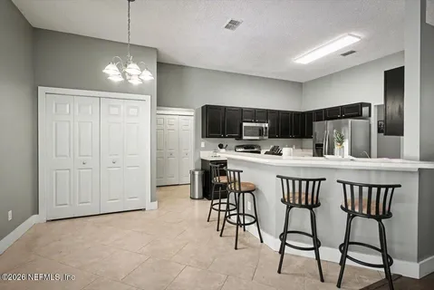a kitchen with kitchen island a dining table chairs cabinets and appliances