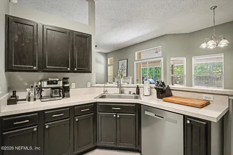a kitchen with stainless steel appliances granite countertop a sink a stove and cabinets