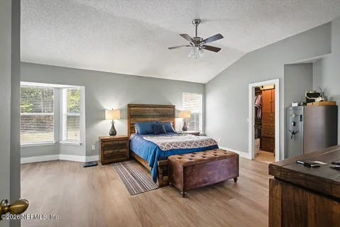 a bedroom with a bed and a flat tv screen on a dresser