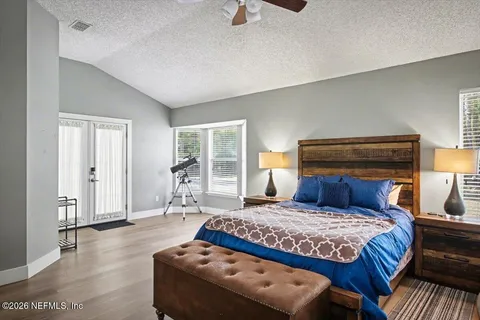 a bedroom with a bed and wooden floor