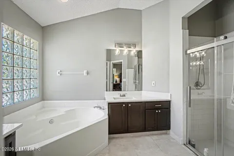 a spacious bathroom with a tub sink shower and mirror