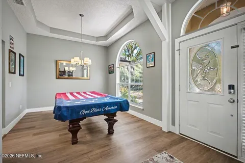 a room with pool table and windows