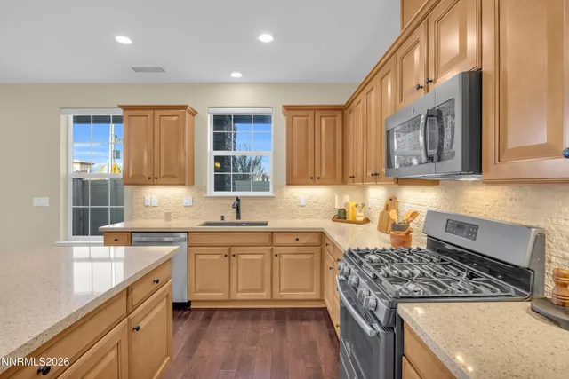 a kitchen with stainless steel appliances granite countertop a stove a sink dishwasher and a refrigerator