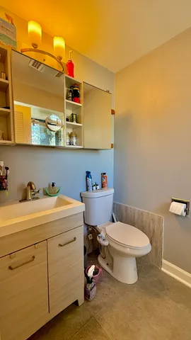 a bathroom with a toilet sink vanity and mirror