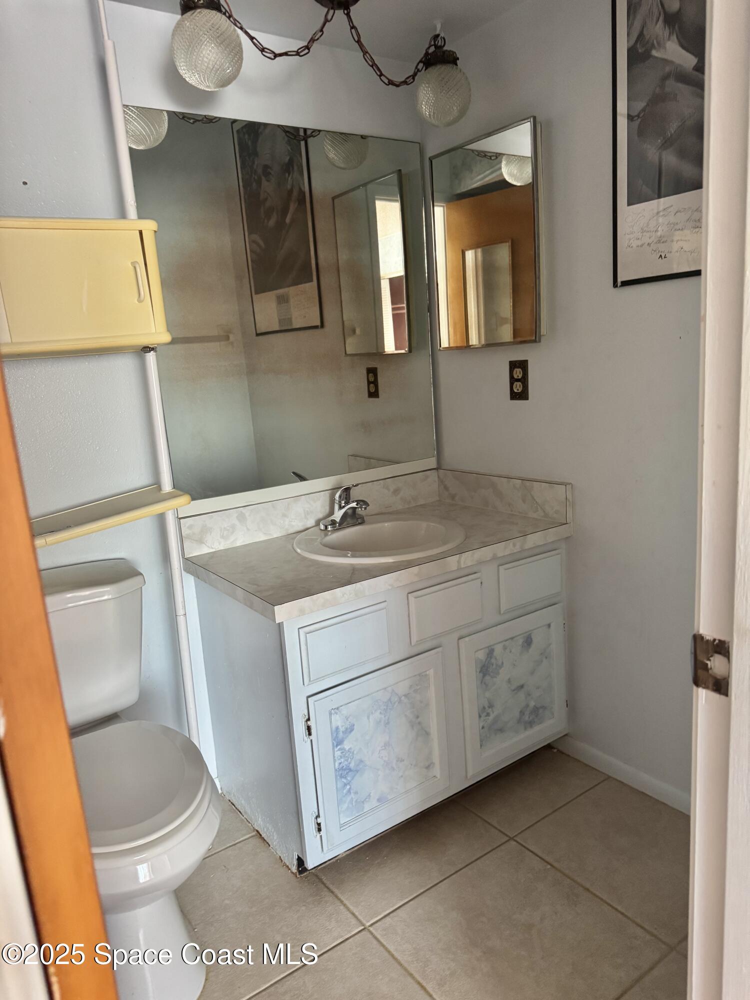 212 Augusta Way Melbourne, FL 32940 - Photo 13 of 49 a bathroom with a sink a toilet and mirror