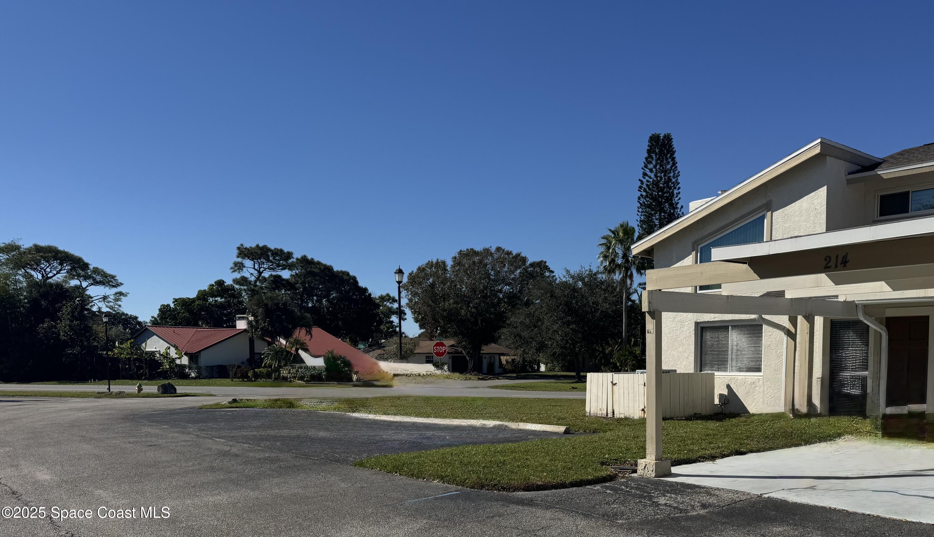212 Augusta Way Melbourne, FL 32940 - Photo 2 of 49 a view of a white house with a big yard and large trees
