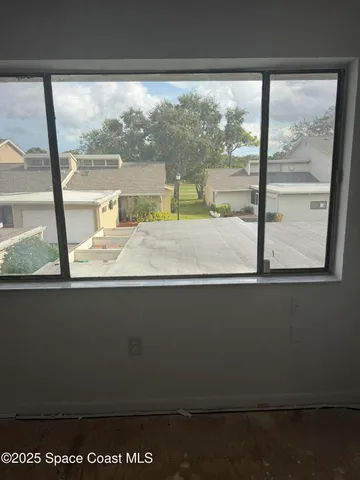 a view of a room with a ceiling fan and a window