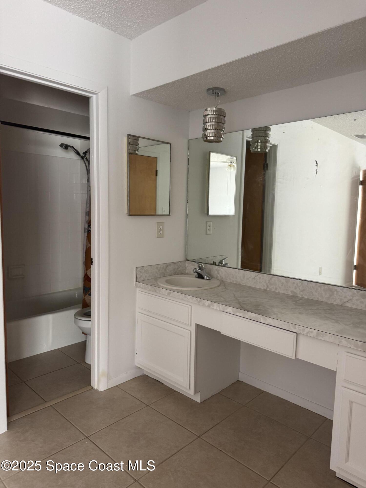 212 Augusta Way Melbourne, FL 32940 - Photo 47 of 49 a bathroom with a double vanity sink a mirror and a bathtub