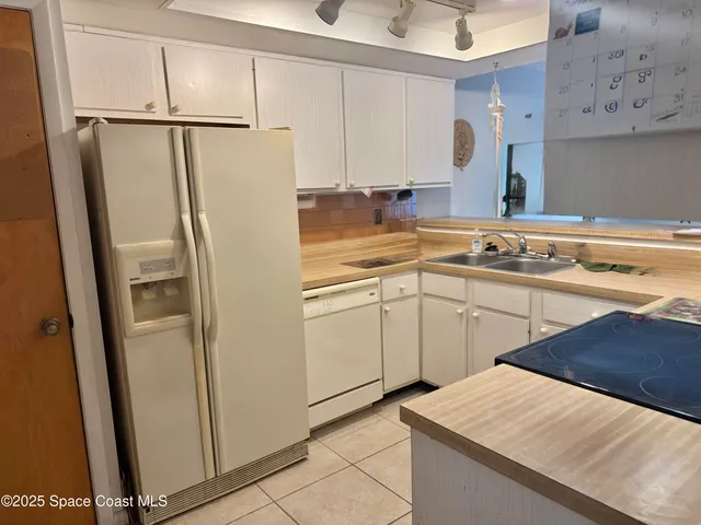 a kitchen with white cabinets and white appliances