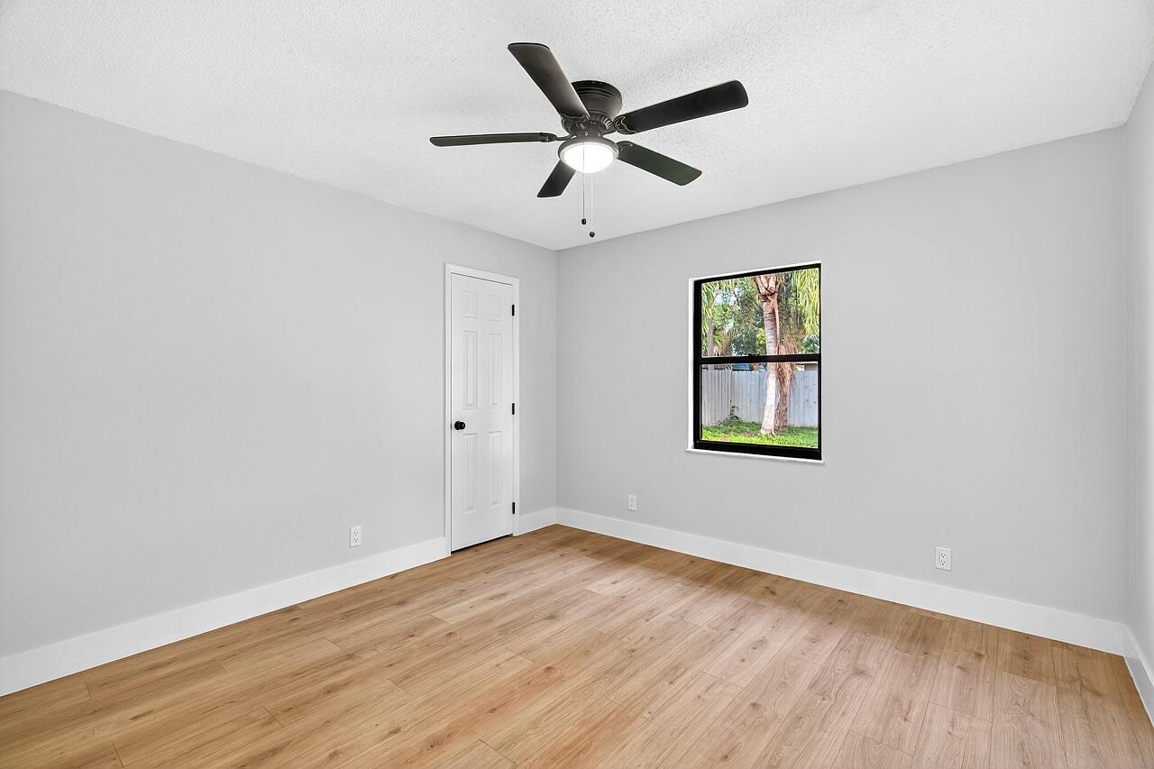 117 High Court Sebastian, FL 32958 - Photo 38 of 54 an empty room with wooden floor ceiling fan and windows