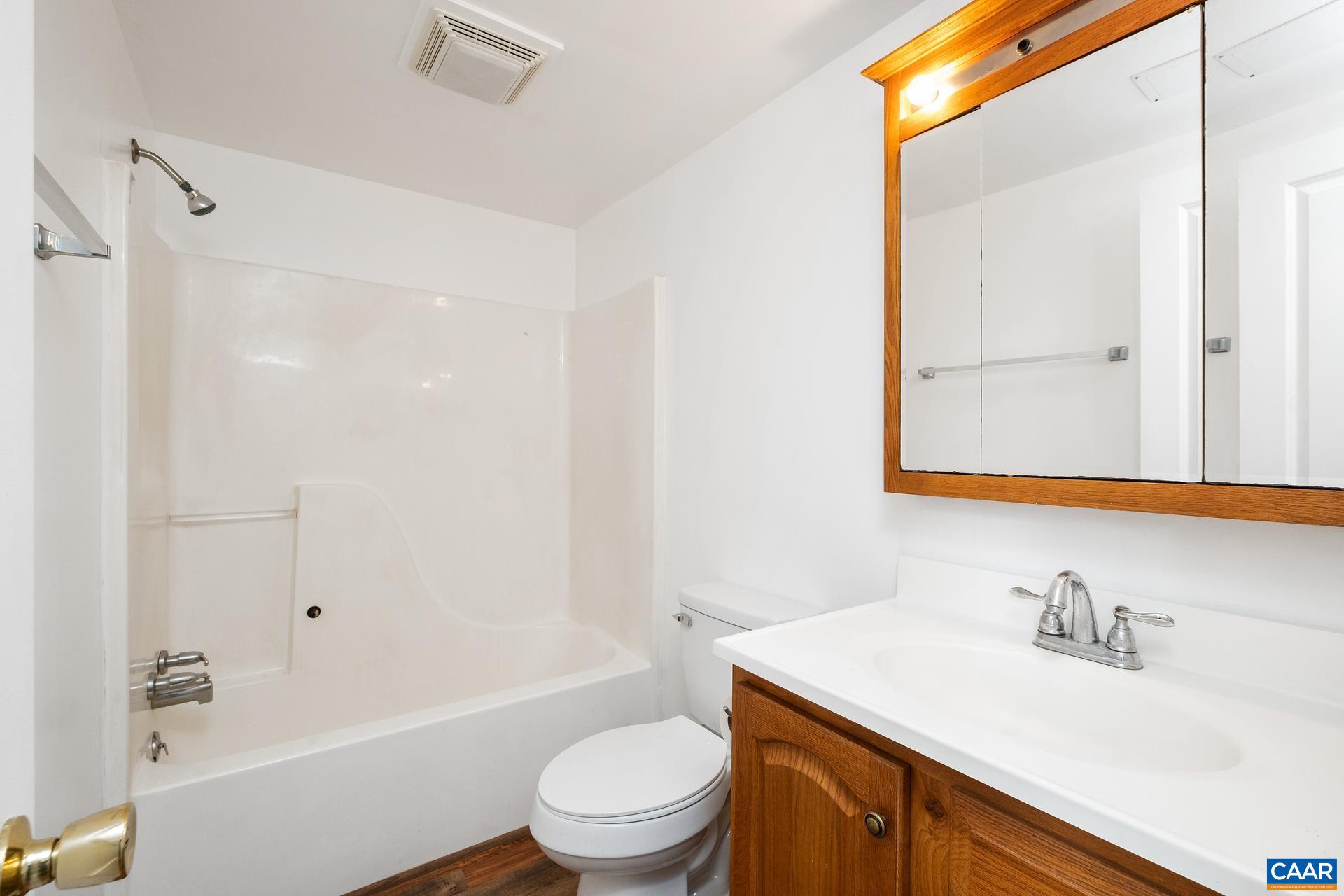 187 Logtrac Road Stanardsville, VA 22973 - Photo 11 of 19 a bathroom with a granite countertop sink toilet a mirror and shower