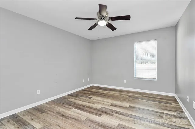 a view of a room with a ceiling fan and window