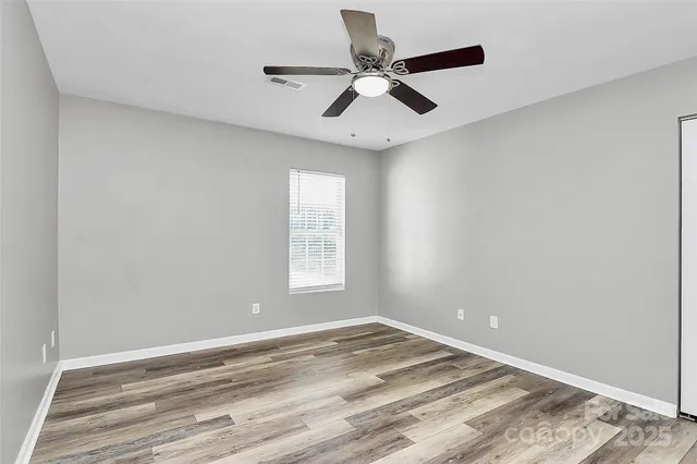 an empty room with a window and a ceiling fan