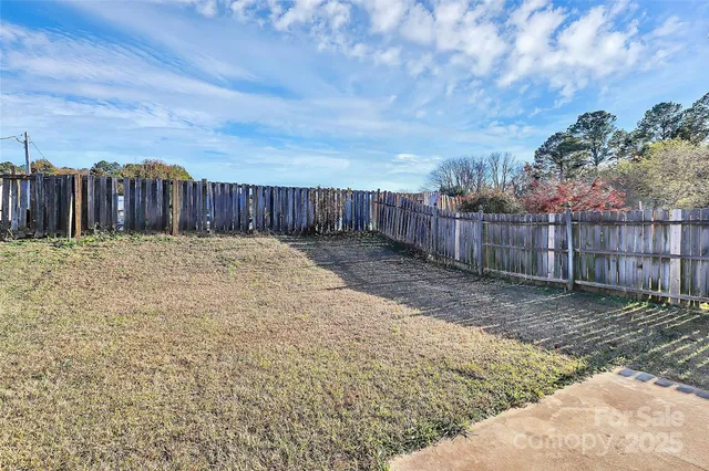 a view of a backyard with wooden fence