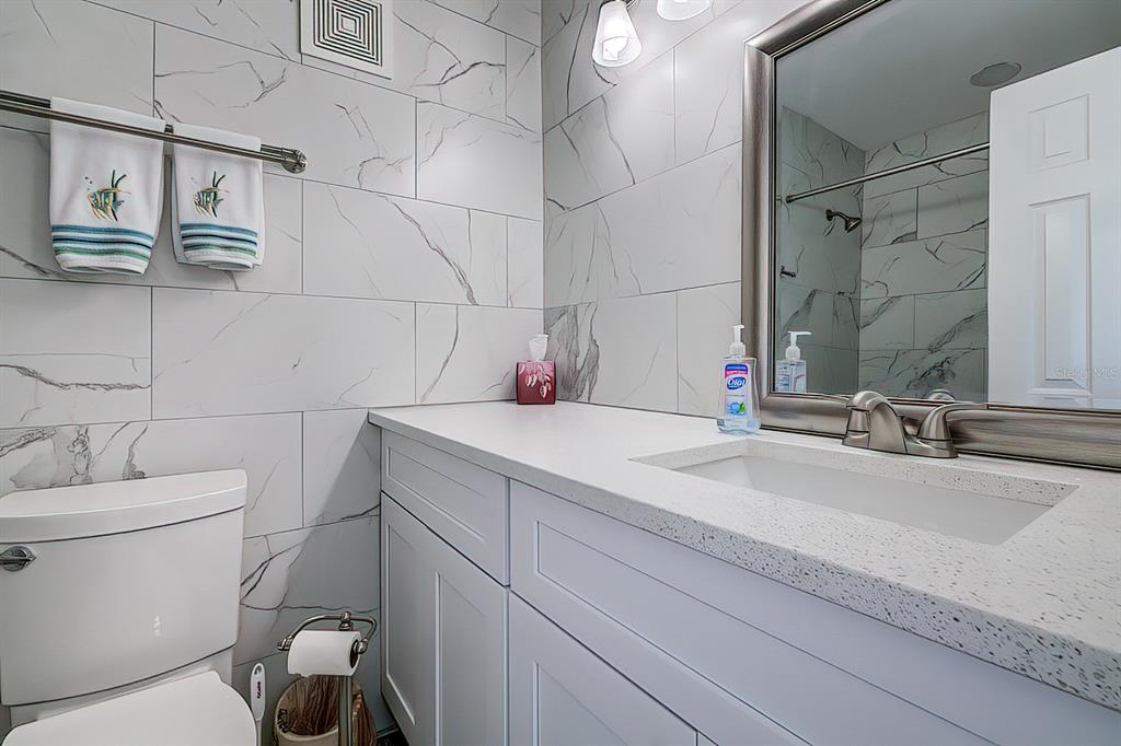161 Medallion Boulevard, Unit E Madeira Beach, FL 33708 - Photo 8 of 19 a bathroom with a sink toilet vanity and shower