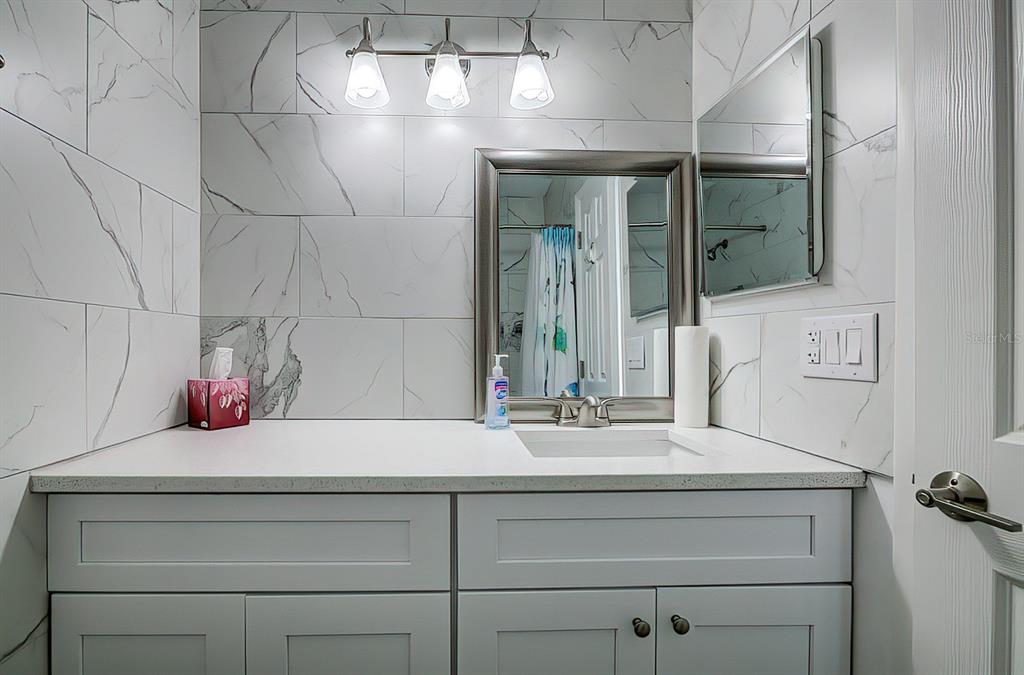 161 Medallion Boulevard, Unit E Madeira Beach, FL 33708 - Photo 10 of 19 a bathroom with a sink and a mirror