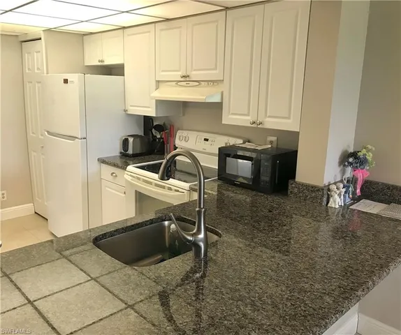 a kitchen with stainless steel appliances a stove a refrigerator and a sink
