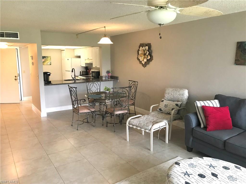 1085 Forest Lakes Drive, Unit 8106 Naples, FL 34105 - Photo 15 of 27 a view of a dining room with furniture and wooden floor