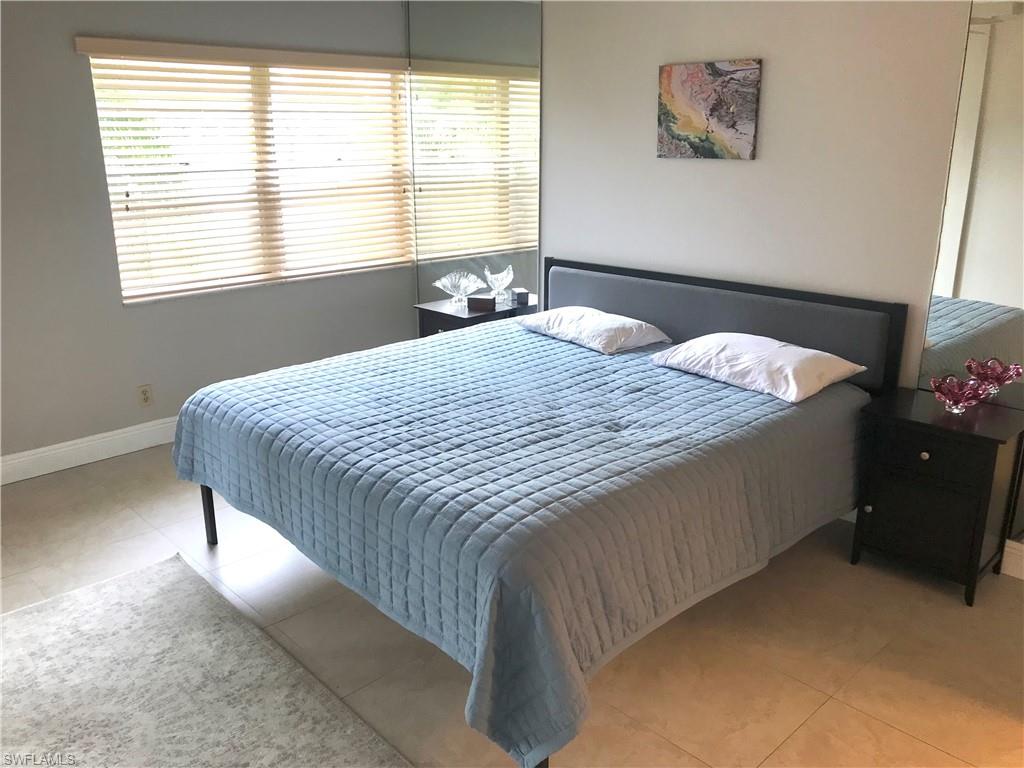 1085 Forest Lakes Drive, Unit 8106 Naples, FL 34105 - Photo 17 of 27 a bedroom with a bed and window