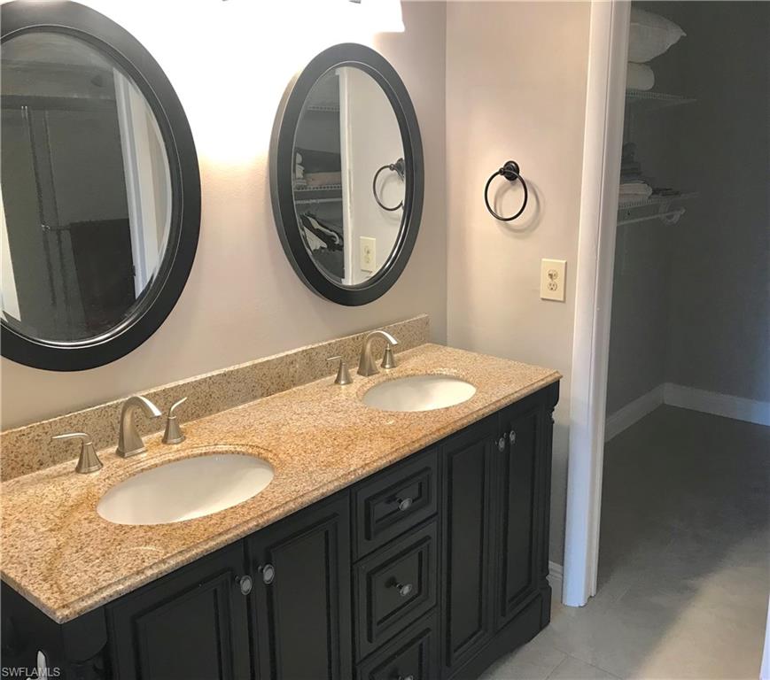 1085 Forest Lakes Drive, Unit 8106 Naples, FL 34105 - Photo 19 of 27 a bathroom with a granite countertop double vanity and a mirror