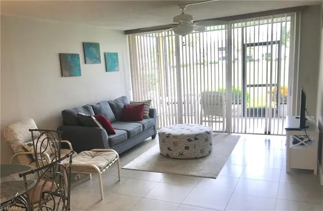 a living room with furniture and a floor to ceiling window