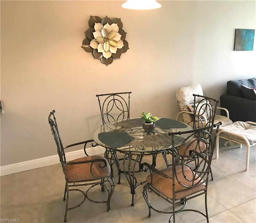 1085 Forest Lakes Drive, Unit 8106 Naples, FL 34105 - Photo 23 of 27 a view of a dining room with furniture and chandelier