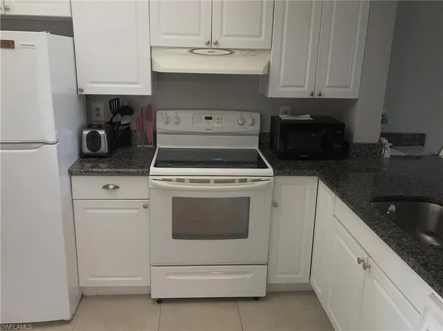 a kitchen with white cabinets and white appliances