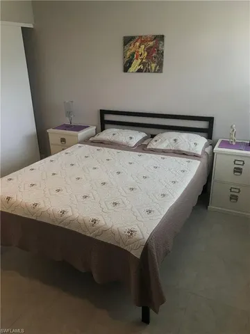 a bedroom with a bed and painting on the wall