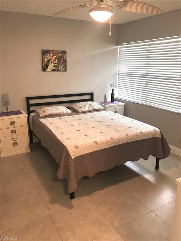 1085 Forest Lakes Drive, Unit 8106 Naples, FL 34105 - Photo 27 of 27 a bed sitting in a bedroom next to a window