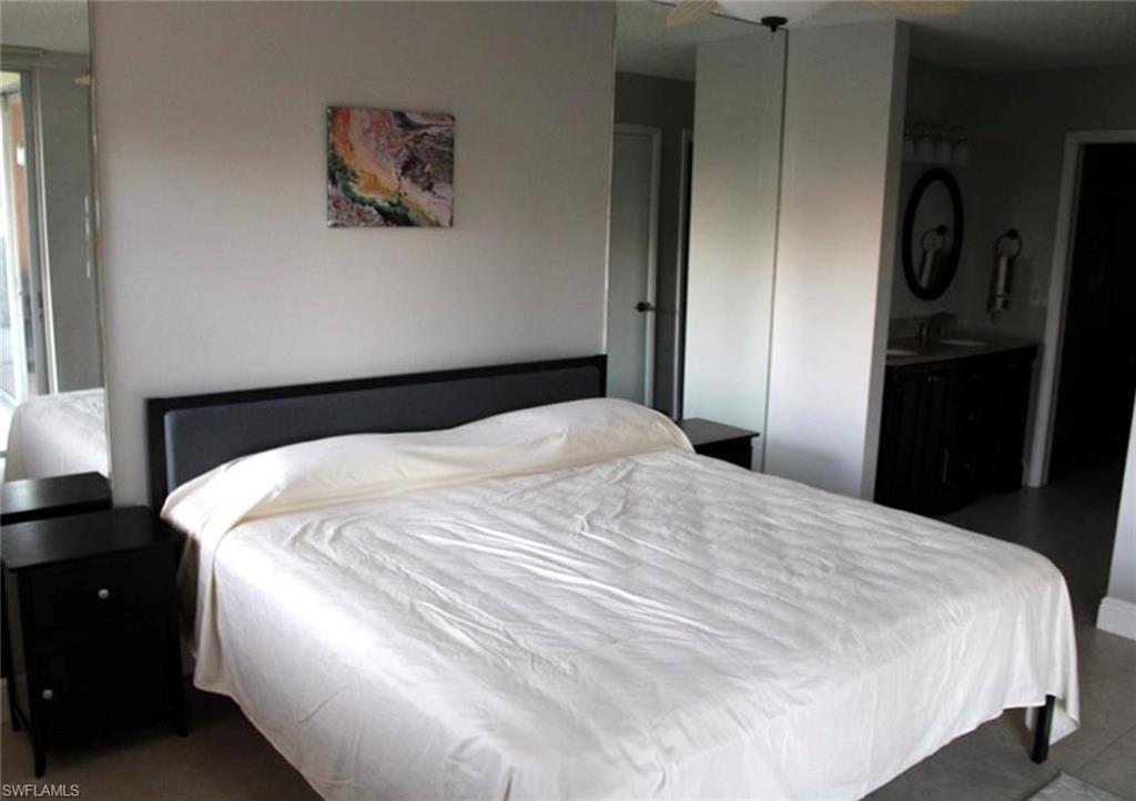 1085 Forest Lakes Drive, Unit 8106 Naples, FL 34105 - Photo 4 of 27 a large white bed in a bedroom next to a window