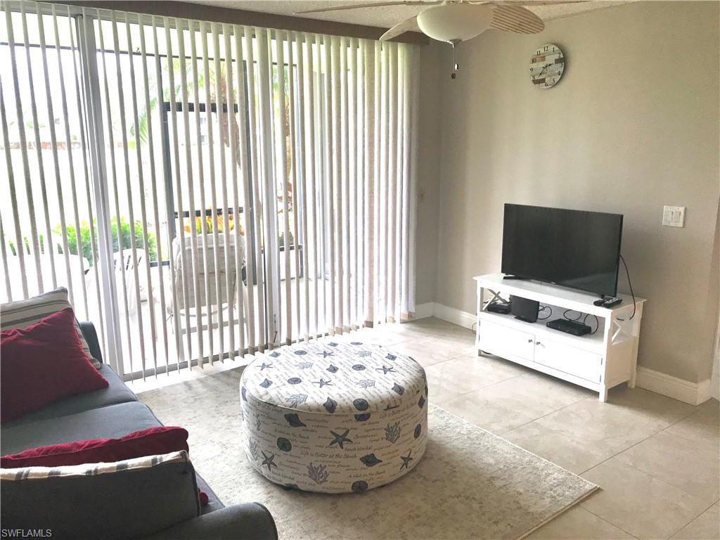 1085 Forest Lakes Drive, Unit 8106 Naples, FL 34105 - Photo 7 of 27 a living room with furniture and a flat screen tv