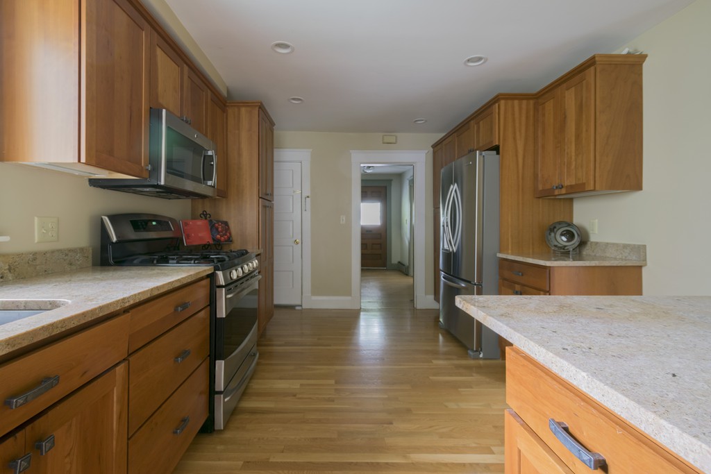 4 Reed Street Lexington, MA 02421 - Photo 12 of 30 a kitchen with stainless steel appliances granite countertop a sink a stove and a wooden cabinets