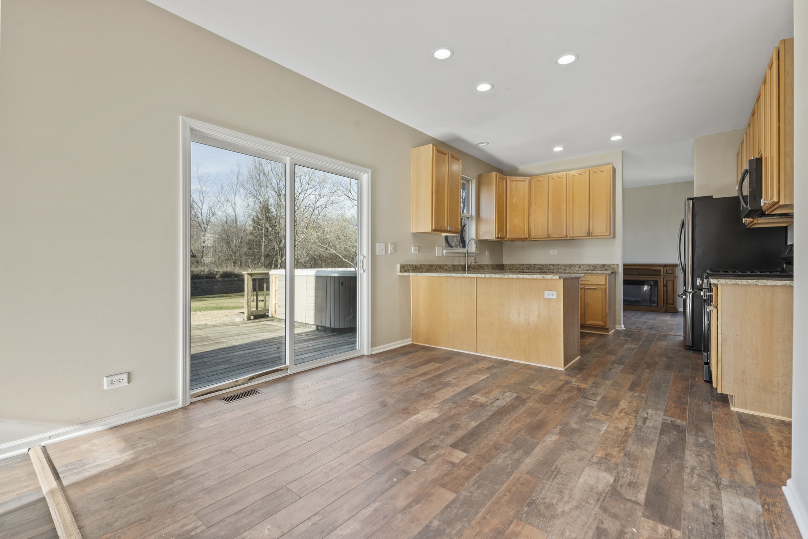 32804 Bending Creek Road Lakemoor, IL 60051 - Photo 14 of 42 a view of a kitchen with kitchen island a sink wooden floor and a refrigerator