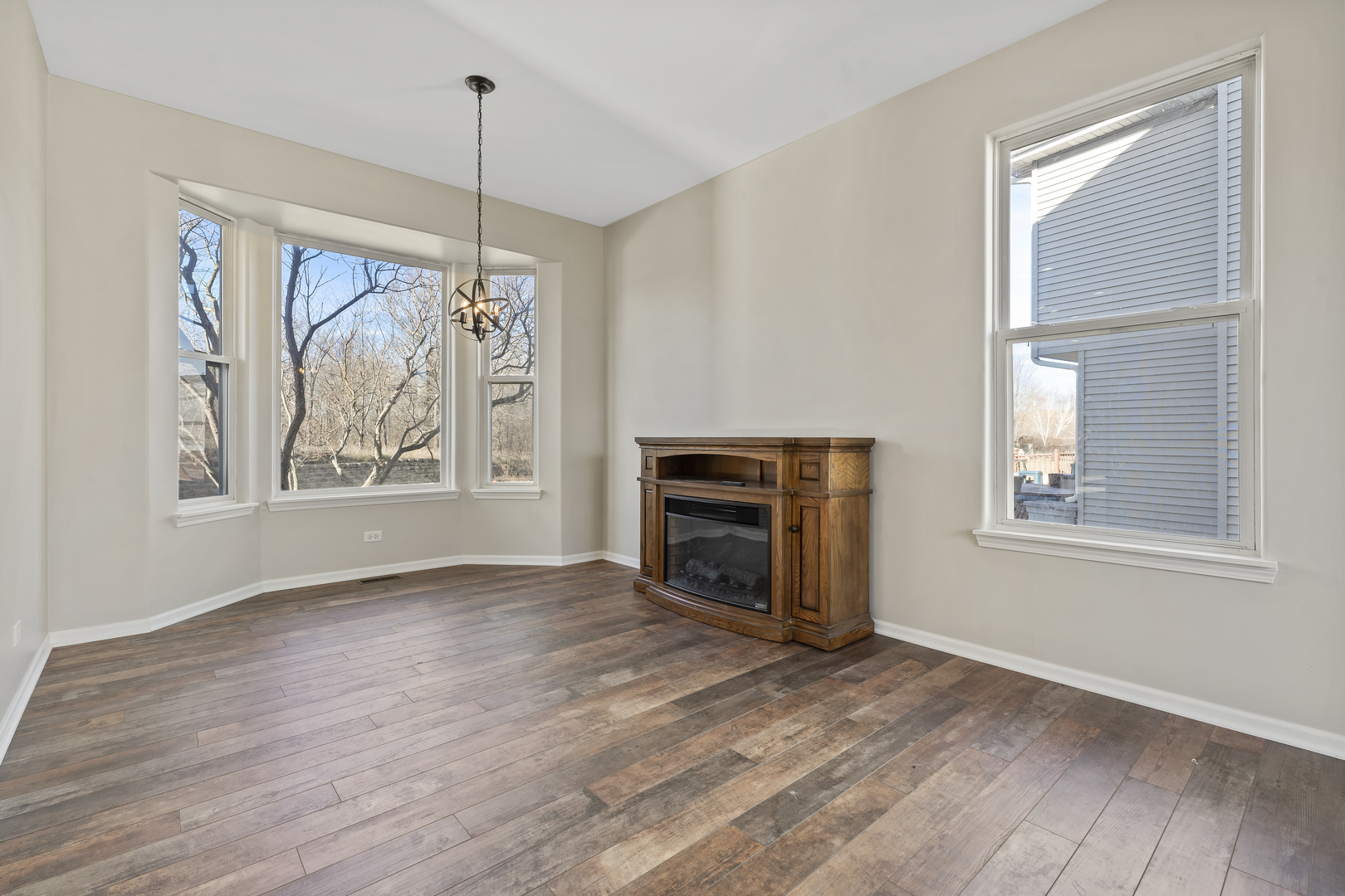 32804 Bending Creek Road Lakemoor, IL 60051 - Photo 8 of 42 a view of empty room with wooden floor fireplace and windows