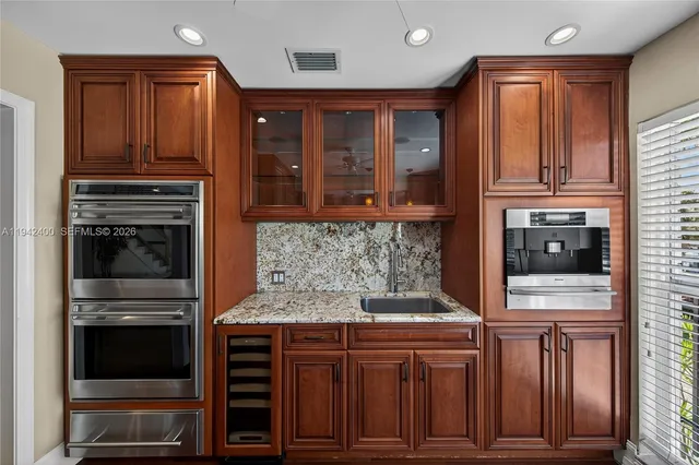 a bathroom with a granite countertop toilet sink and mirror