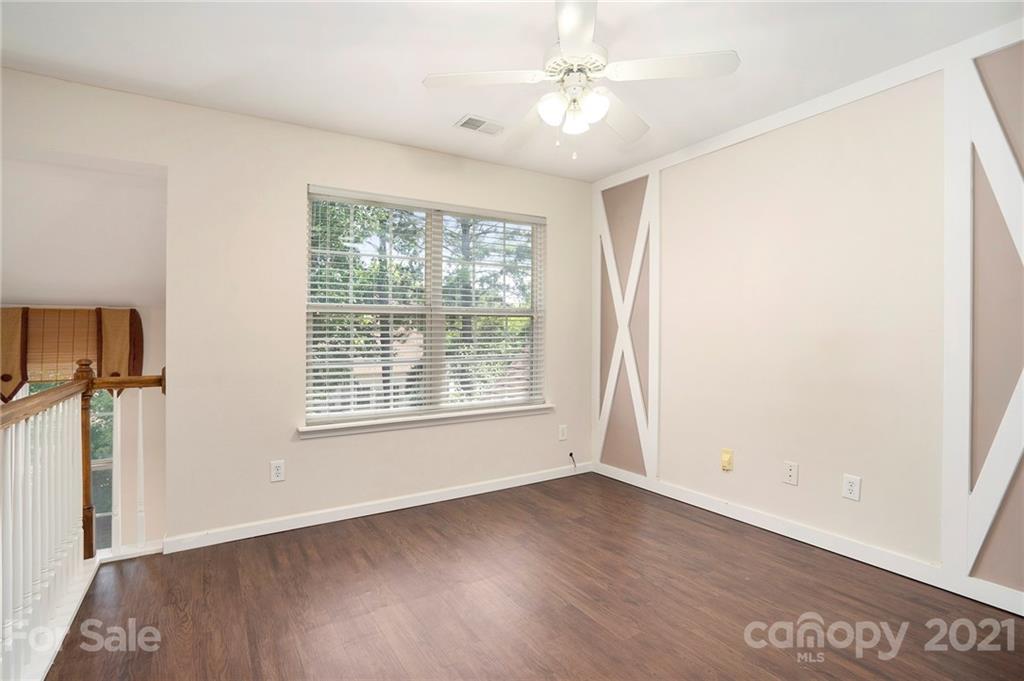 10621 Fuller Ridge Circle Charlotte, NC 28270 - Photo 15 of 32 a view of an empty room with a window and wooden floor