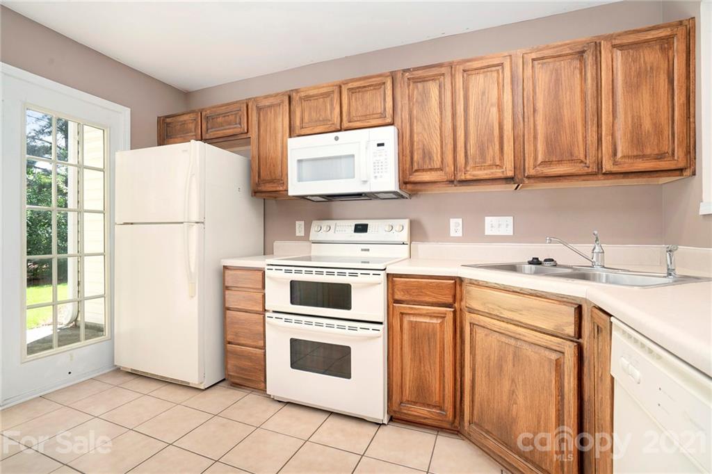 10621 Fuller Ridge Circle Charlotte, NC 28270 - Photo 3 of 32 a kitchen with white cabinets and white appliances