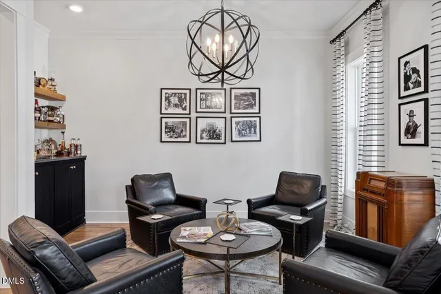 a living room with furniture a rug and wall paintings