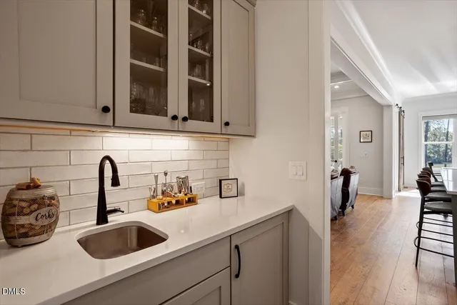 a kitchen with a sink and a stove with wooden floor