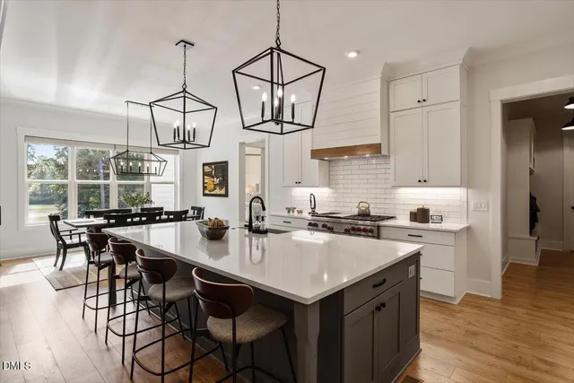 a kitchen with a table chairs stove and wooden floor