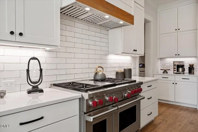 a kitchen with a stove and white cabinets