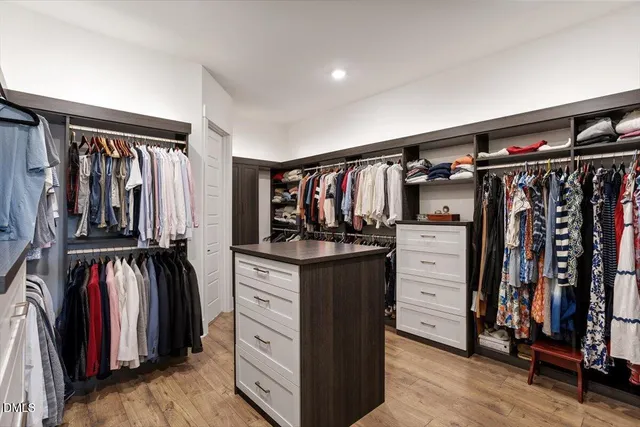 a view of walk in closet with clothes