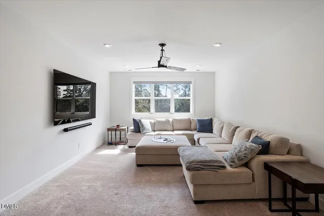 a living room with furniture a window and a flat screen tv